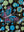 Close-up of a butterfly drawn in magenta, blue and white linework among turquoise and sage dots on black canvas — Tangled Monk original hand-drawn art