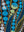Close-up of large turquoise and sage bubbles with white highlights drifting between curving reeds, the canvas weave visible — Tangled Monk original hand-drawn art